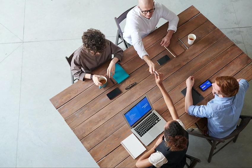 A group of people sitting at a table working together. A group of people sitting at a table working together.
